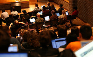 heweb08_computers2 A view of attendees -- and their sea of glowing laptops & other devices -- in a #heweb08 general conference session.